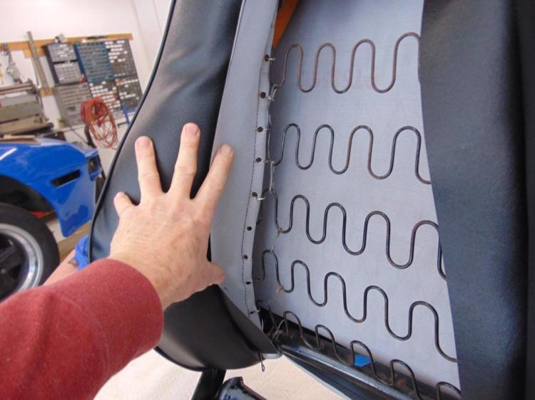 The row of black circles are where I used a one hole punch to make openings where the hog rings can go. There is a wire embedded along this edge. The hog rings will attach to the wavy seat frame wires.