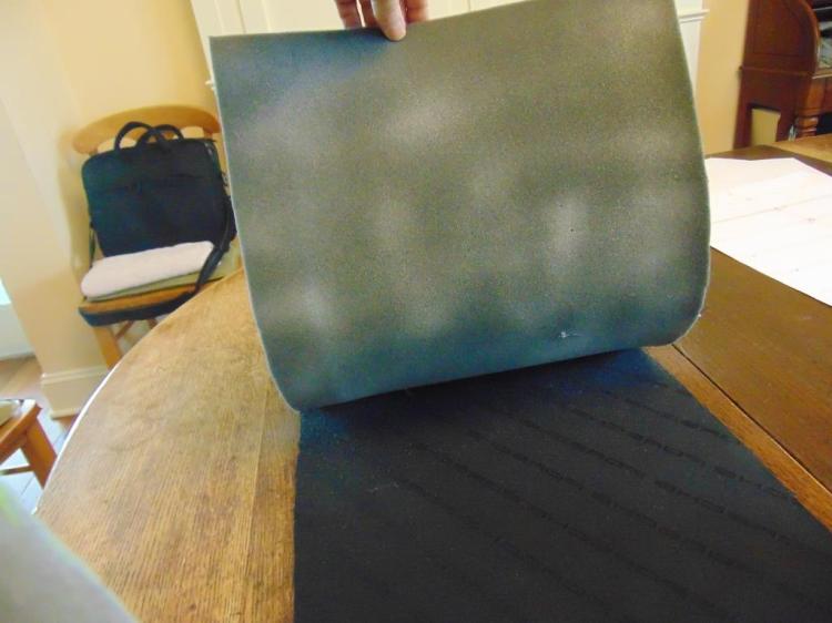 In this picture, the fabric is laid face down and the foam is being glued to it with the basting spray, which shows as whitish streaks in this picture.